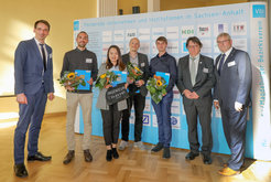 Prof. Rüdiger Bähr, Vorsitzender des VDI Magdeburger BV, überreichte die Urkunden und das Preisgeld im Beisein des Staatssekretärs Dr. Jürgen Ude, Ministerium für Wirtschaft, Wissenschaft und Digitalisierung des Landes Sachsen-Anhalt, sowie des Vorsitzenden des VDI LV Sachsen-Anhalts, Hon.-Prof. Mirko Peglow.
v.l.n.r.: Prof. Mirko Peglow | Sebastián López Castellanos, M.Sc. | Feng Xie, M.Sc. | Dr. Max Köchig | Heinz Blath M. Eng. | Prof. Rüdiger Bähr | Staatssekretär Dr. Jürgen Ude