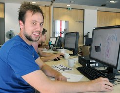 Robin Lukas Semrau arbeitet im Tutorial zu „Brownian Hydro Dynamics of Particulate Suspensions“, geleitet von Aleksandar Donev von der New York University, mit. Auf dem Bildschirm sind zwei Kolloidpartikel zu sehen, die sich aufgrund eines rotierenden magnetischen Feldes umeinander drehen. In diesem Bild wird die Brownsche Bewegung illustriert.