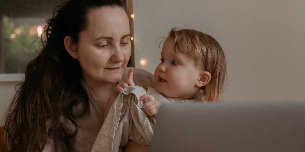 A mother and a young child looking at each other.