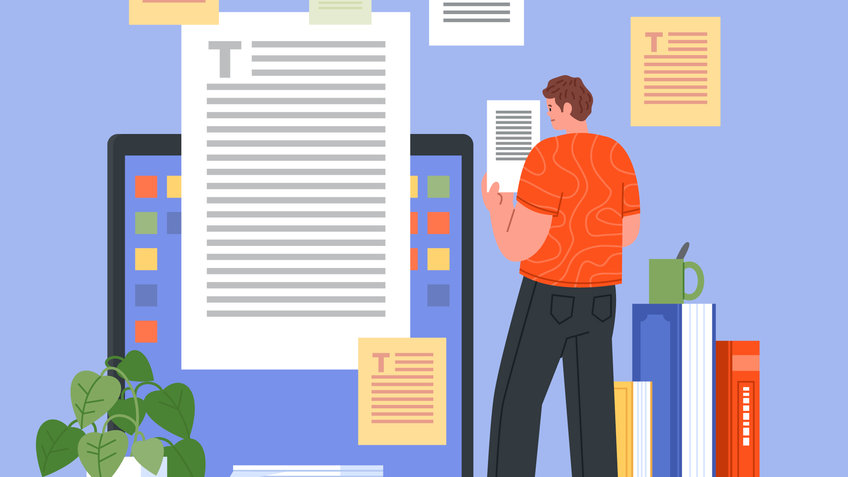 Publication Management Individual in an orange shirt reviewing documents near a laptop, surrounded by papers and books.