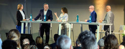 A panel discussion with five speakers on stage addressing an audience, including Dietmar Harhoff, Director at the Max Planck Institute for Innovation and Competition, Susanne Kadner, Co-Founder of CIRCULAR REPUBLIC & Director of UnternehmerTUM, Kai Sundmacher, Director at the Max Planck Institute for Dynamics of Complex Technical Systems, and Ralf P. Thomas, Chief Financial Officer of Siemens AG.